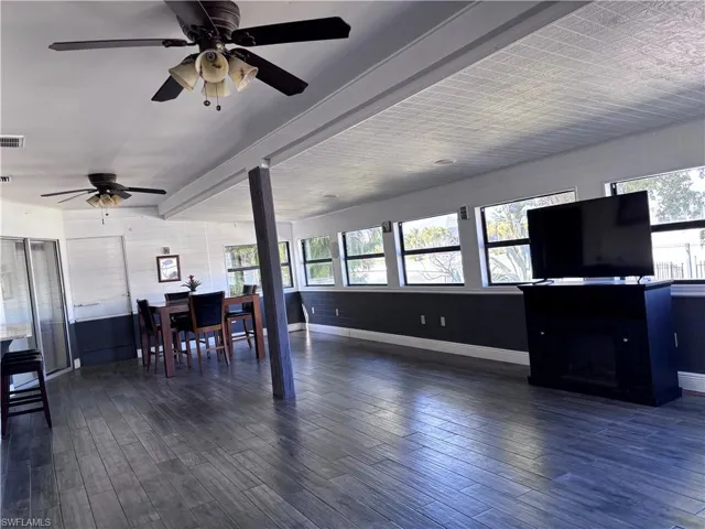 Living area featuring dark wood-style flooring and ceiling fan