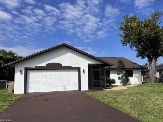 Single story home with stucco siding, a sunroom, a front yard, and driveway