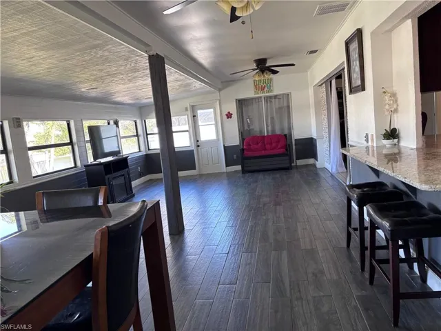 Dining room featuring dark wood-type flooring, ornamental molding, and ceiling fan