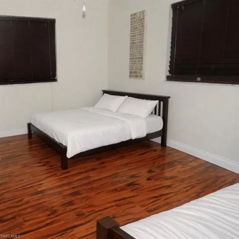 Bedroom featuring wood finished floors and baseboards