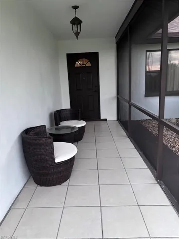 Property entrance featuring a sunroom and stucco siding
