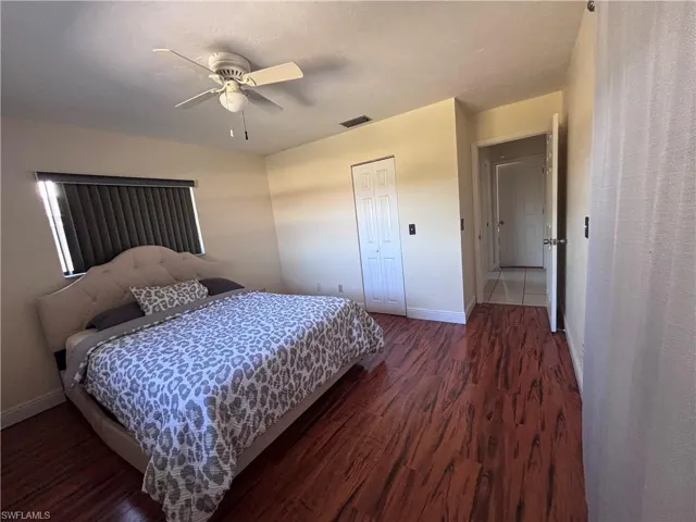 Bedroom featuring dark wood-type flooring, a ceiling fan, and a closet
