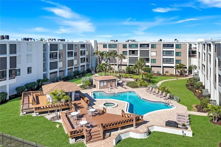 Community pool with a patio area, a hot tub, and a deck