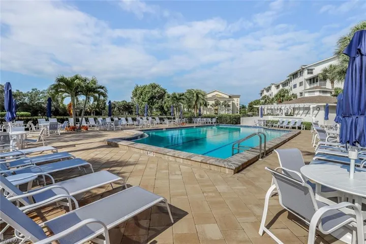 Expansive community swimming pool surrounded by a large paver deck