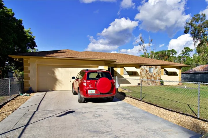 Single story home featuring a garage and a front lawn