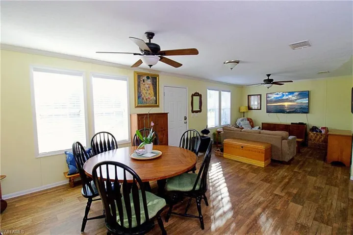 Dining room featuring ceiling fan, dark hardwood / wood-style floors, and crown molding