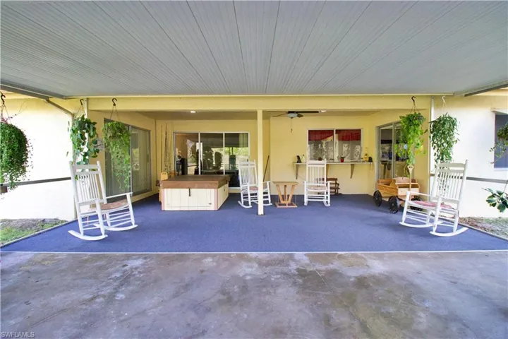 View of patio with ceiling fan and exterior bar