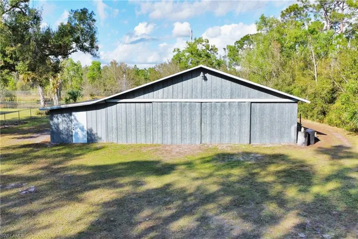 View of property exterior featuring a yard and an outbuilding