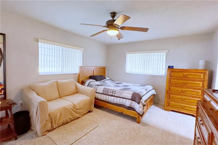 Carpeted bedroom featuring ceiling fan