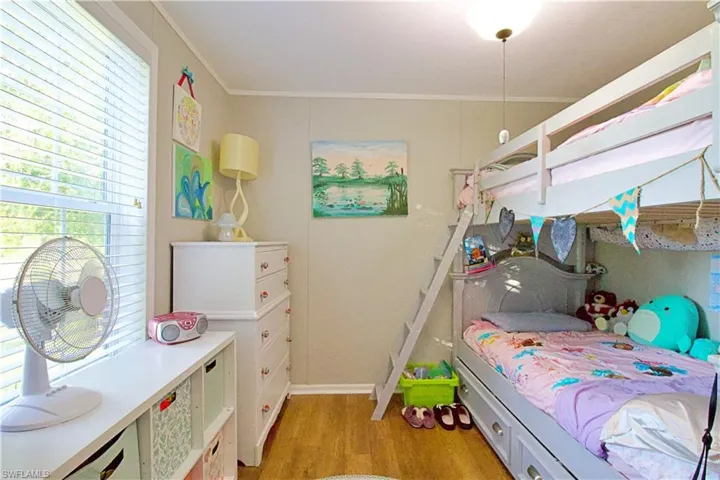Bedroom with light wood-type flooring and ornamental molding