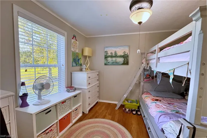 Bedroom featuring dark hardwood / wood-style flooring and ornamental molding