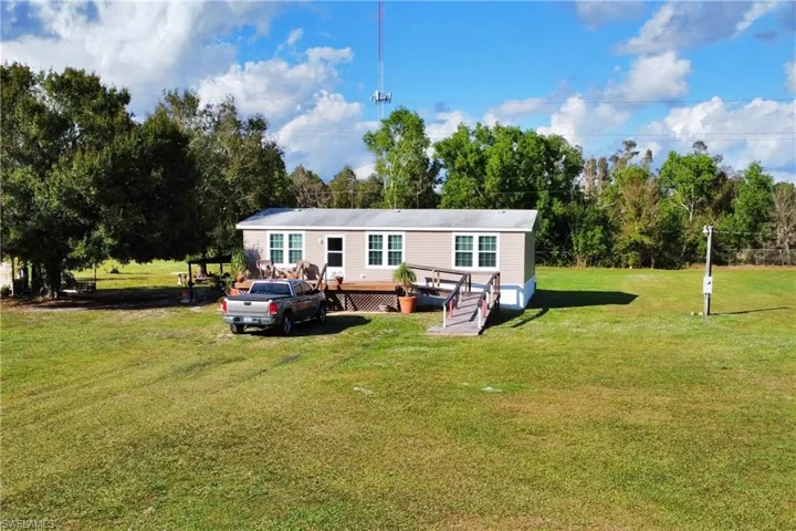 Rear view of house with a lawn and a wooden deck