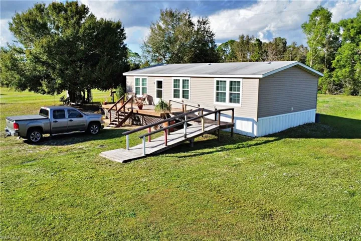 Rear view of house featuring a yard and a deck