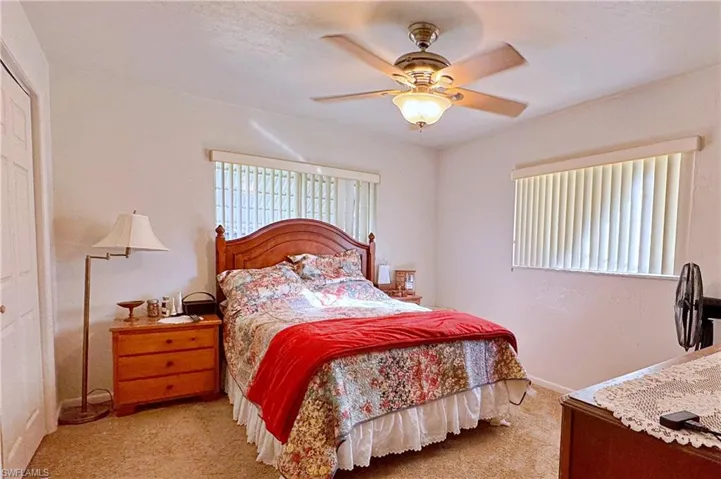 Bedroom featuring ceiling fan, a closet, and light colored carpet