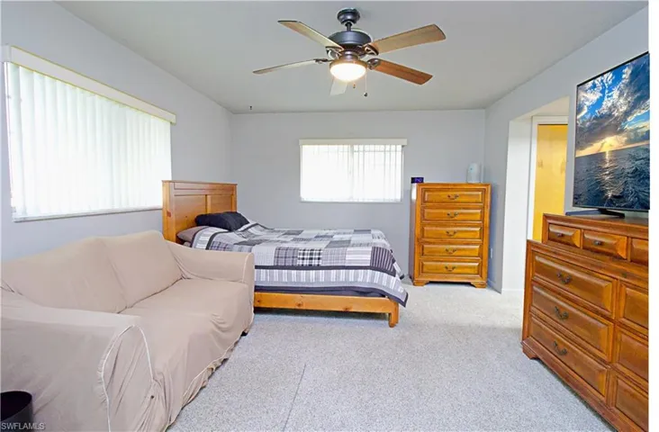 Carpeted bedroom featuring ceiling fan
