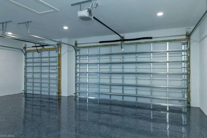Garage featuring a garage door opener and recessed lighting