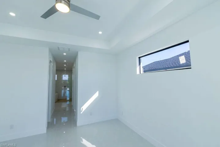 Empty room featuring baseboards, a ceiling fan, recessed lighting, and light marble finish floors