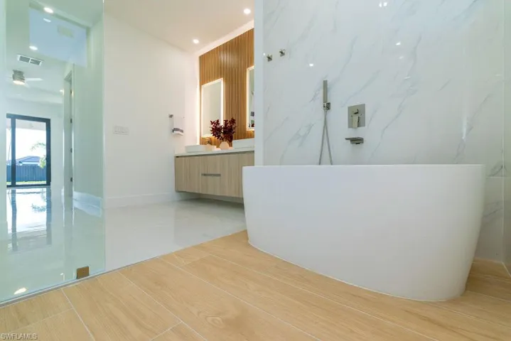 Bathroom with vanity, tile patterned floors, and a freestanding bath