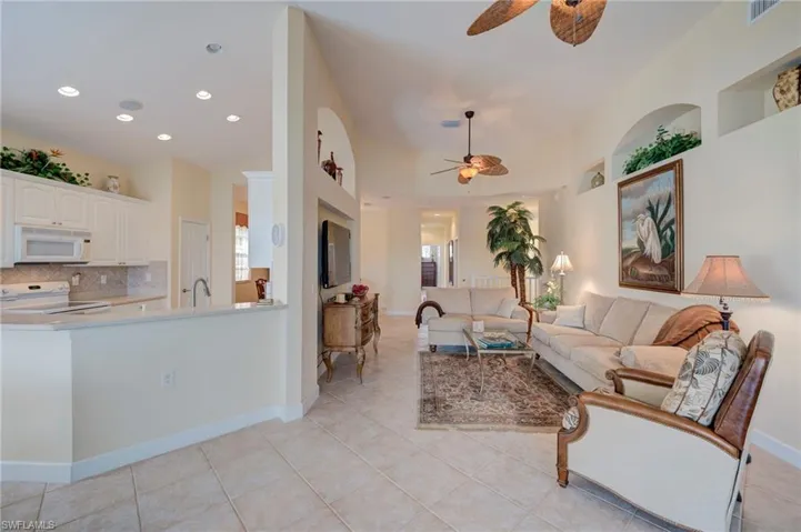 Living area with ceiling fan, light tile patterned floors, and recessed lighting