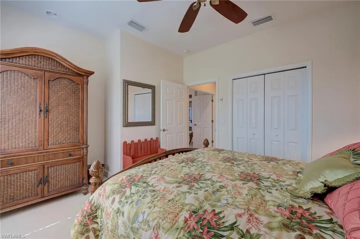 Bedroom featuring light colored carpet, ceiling fan, and a closet