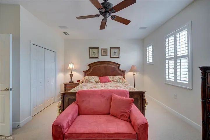 Bedroom featuring ceiling fan, a closet, and light carpet