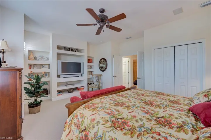 Bedroom with ceiling fan, carpet floors, and a closet