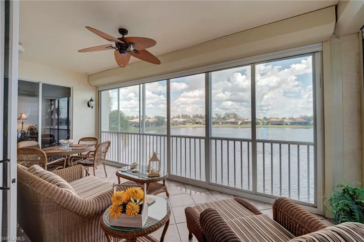Sunroom / solarium featuring tile patterned floors and a water view