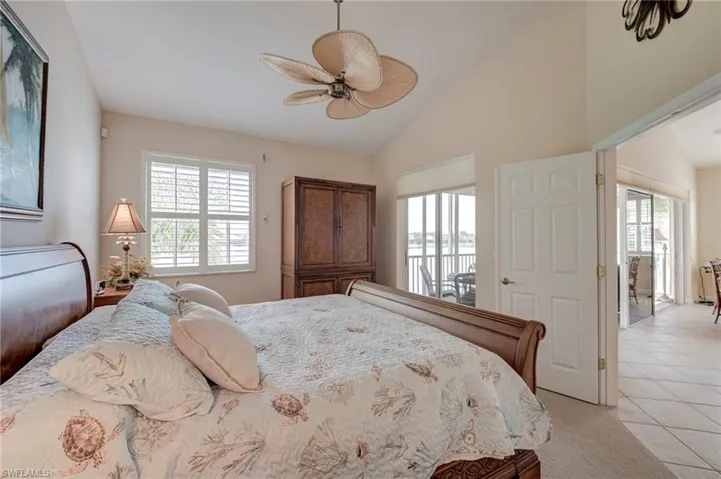 Bedroom featuring multiple windows, a ceiling fan, lofted ceiling, access to exterior, and light tile patterned flooring