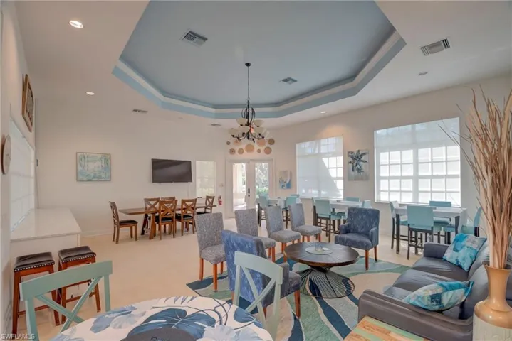 Living room featuring french doors, suspended lighting, and ornamental molding