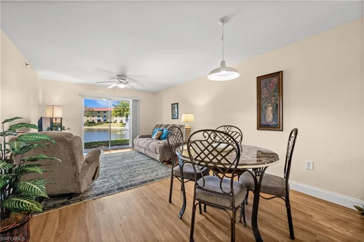 Dining room with wood finished floors, a ceiling fan, and a water view