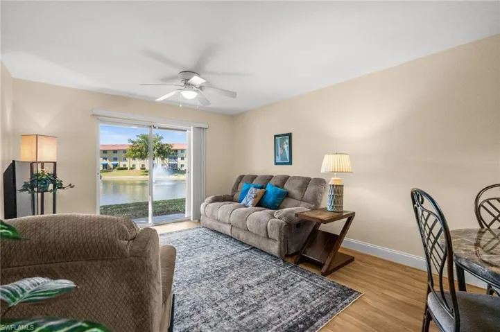 Living area featuring ceiling fan, light wood-style flooring, and a water view