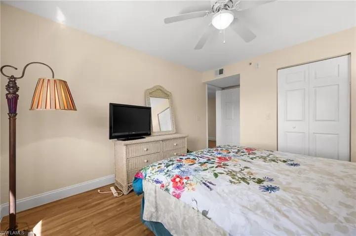 Bedroom with light wood-style flooring, ceiling fan, and a closet