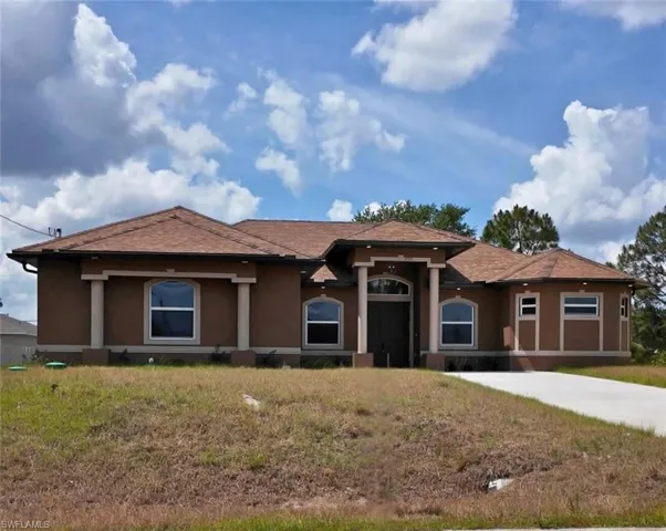 View of front of house featuring a front yard, stucco siding, and a shingled roof