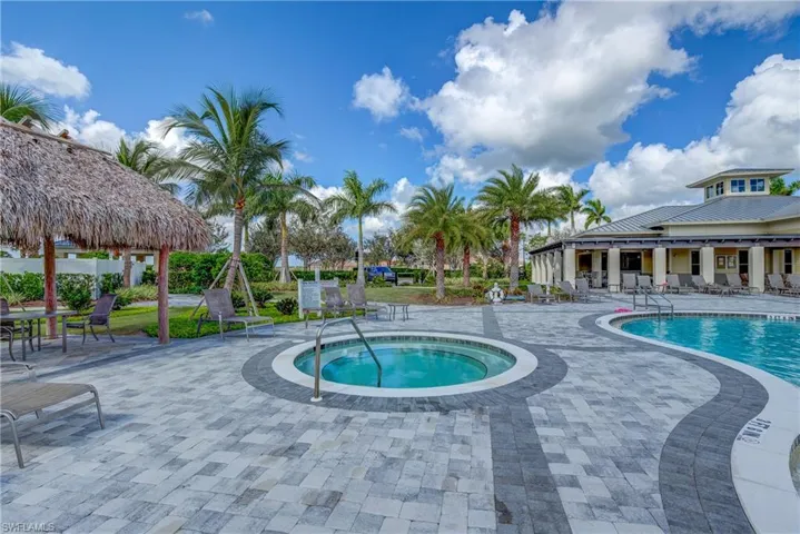 Community pool with a patio area and a hot tub