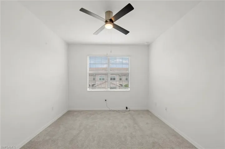 Empty room with ceiling fan and carpet floors