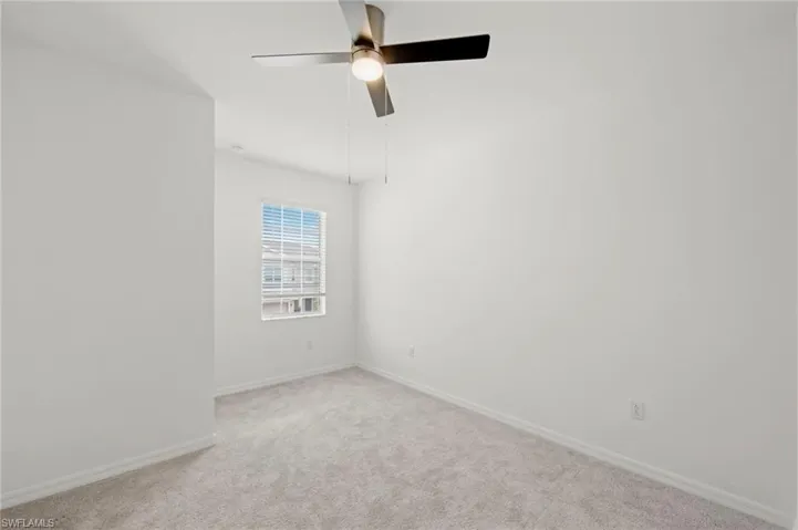 Unfurnished room with carpet and a ceiling fan