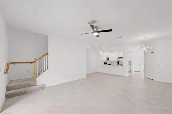 Unfurnished living room with ceiling fan and light tile patterned floors