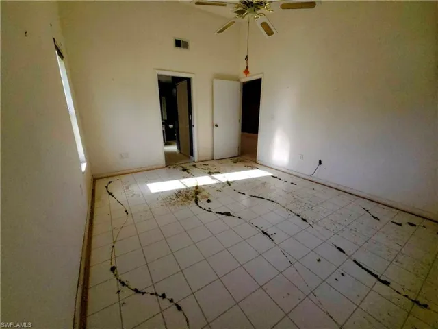 Spare room with ceiling fan and a high ceiling