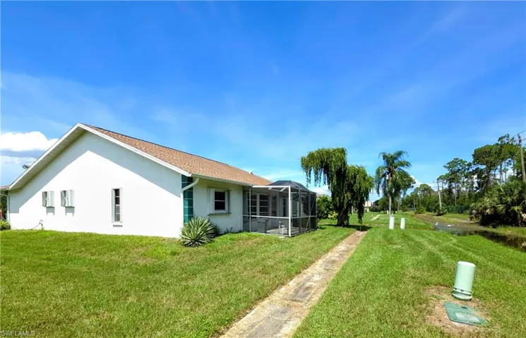 View of green lawn featuring a lanai