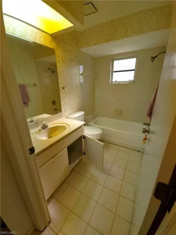 Bathroom featuring tile patterned floors, vanity, and bathtub / shower combination