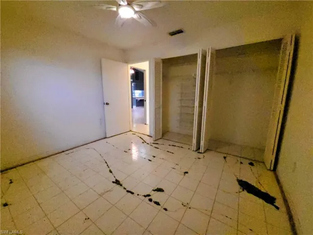 Unfurnished bedroom featuring multiple closets and a ceiling fan