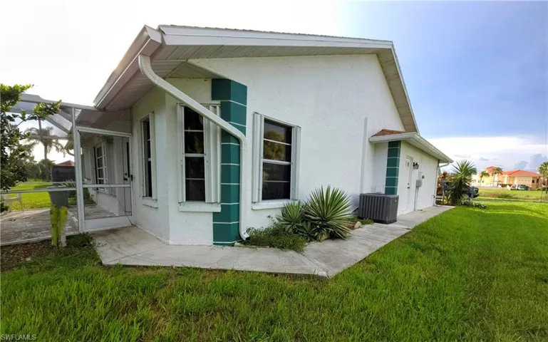 View of side of home featuring stucco siding and a lawn