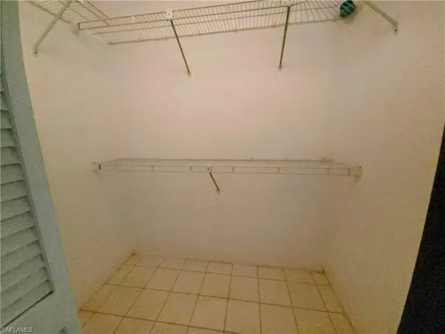 Spacious closet with light tile patterned floors