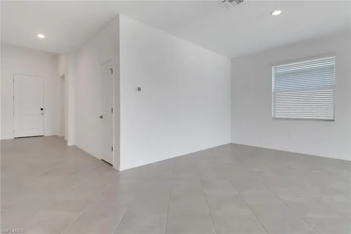 Empty room featuring recessed lighting and visible vents