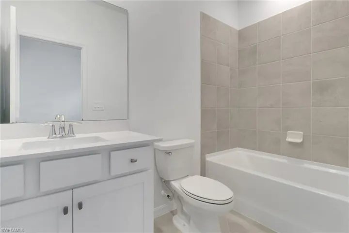 Bathroom featuring bathing tub / shower combination, vanity, and toilet