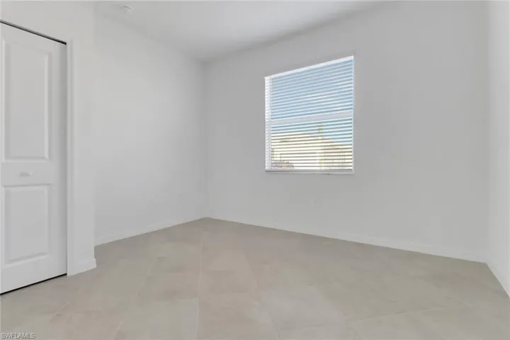 Unfurnished room featuring light tile patterned flooring and baseboards