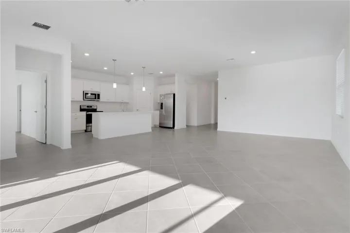 Unfurnished living room featuring recessed lighting, visible vents, and light tile patterned flooring
