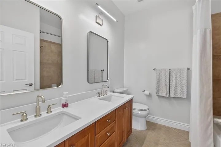 Full bathroom  upstairs featuring double vanity and tub shower combo.