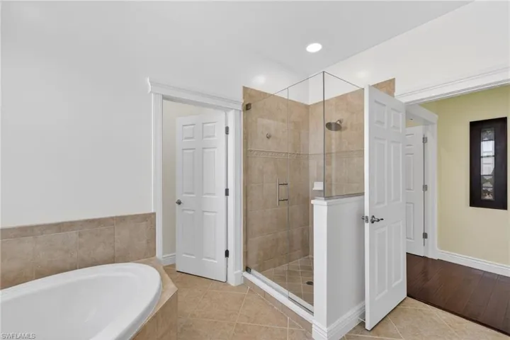 Full bathroom featuring a bath, separate toilet closet and a shower stall.