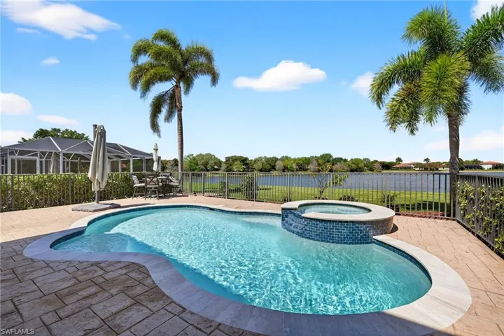Relaxing pool / spa with a patio area, a fenced backyard, a water view, and outdoor dining area.